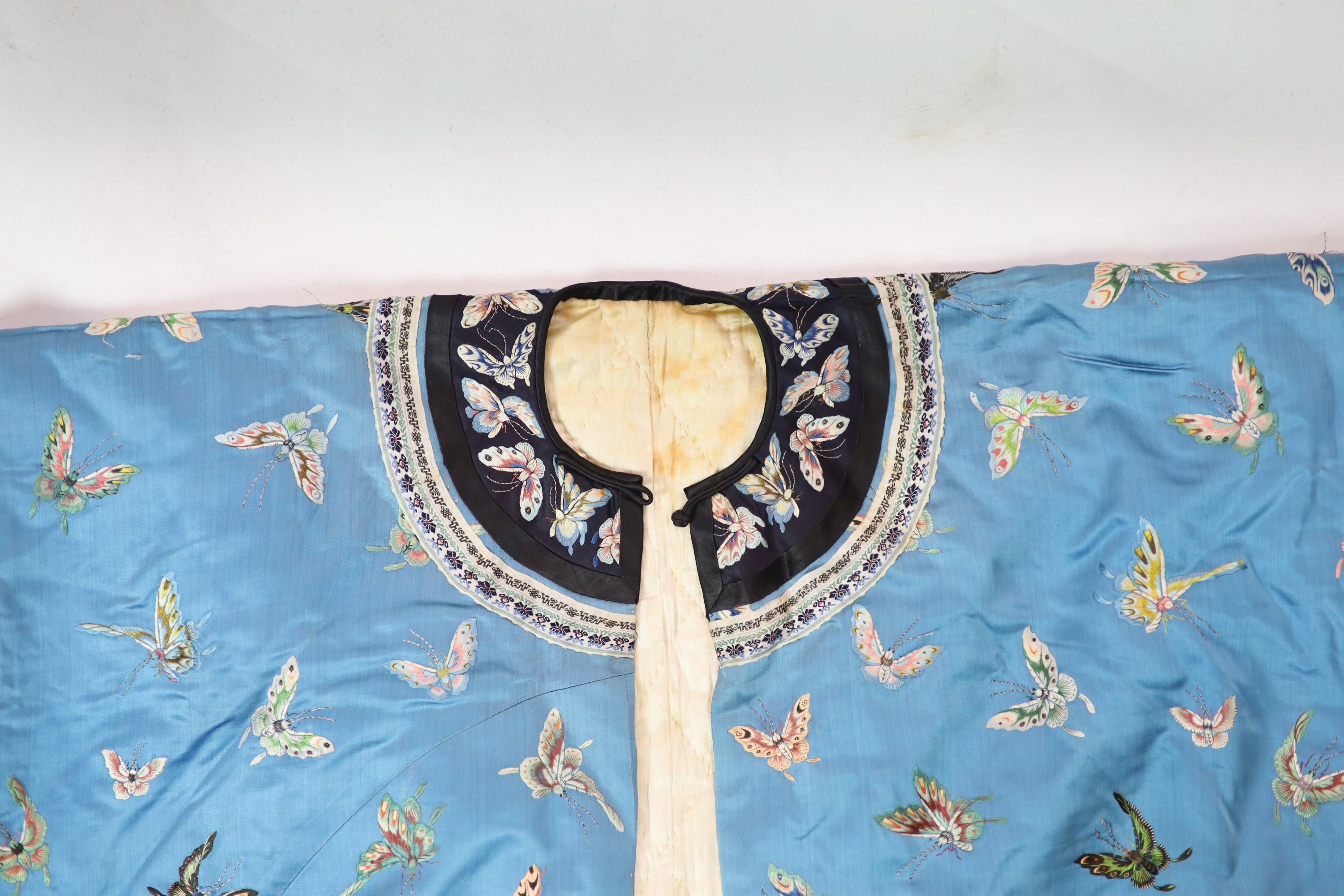 A Chinese blue silk ‘butterfly’ Winter robe, late 19th century, 132cm drop